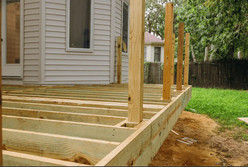 Contractor inspecting deck framing for a full deck restoration