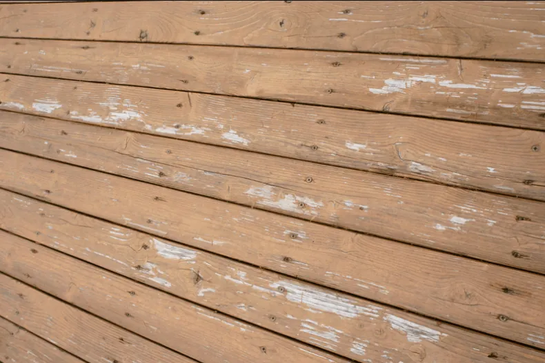 Weathered, cracked deck boards with peeling finish